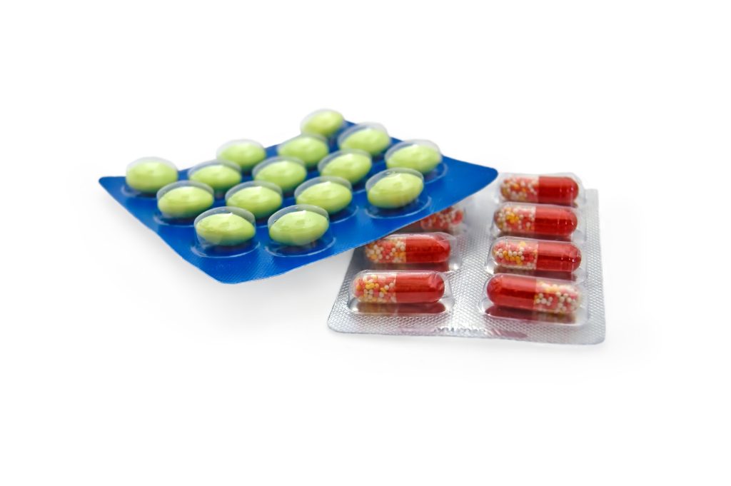Capsules and tablets in packs on a white background